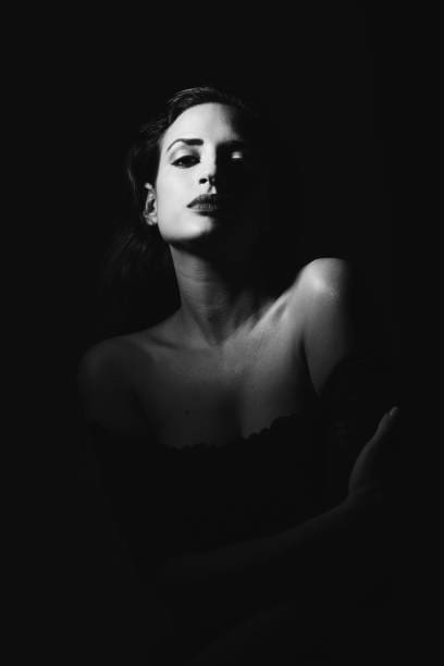 Black and white portrait of a woman with dramatic lighting and shadows.