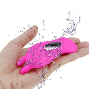 Hand holding a pink waterproof device with water splashing.